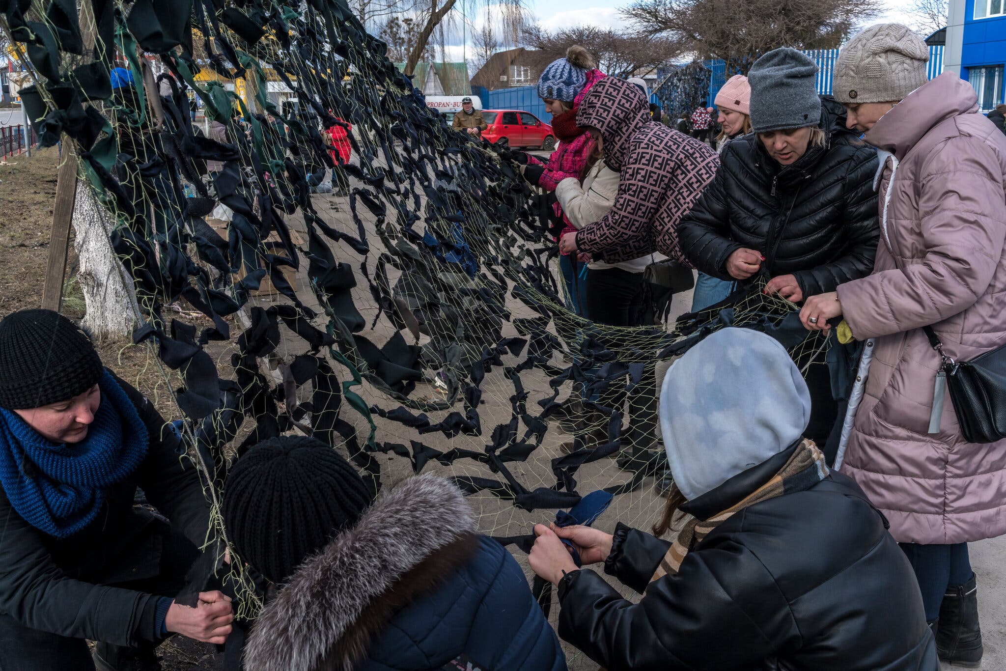 Εθελοντές φτιάχνουν δίχτυα παραλλαγής για να χρησιμοποιηθούν από τον στρατό στην πόλη Kalynivka (Φωτογραφία: Brendan Hoffman - The New York Times)